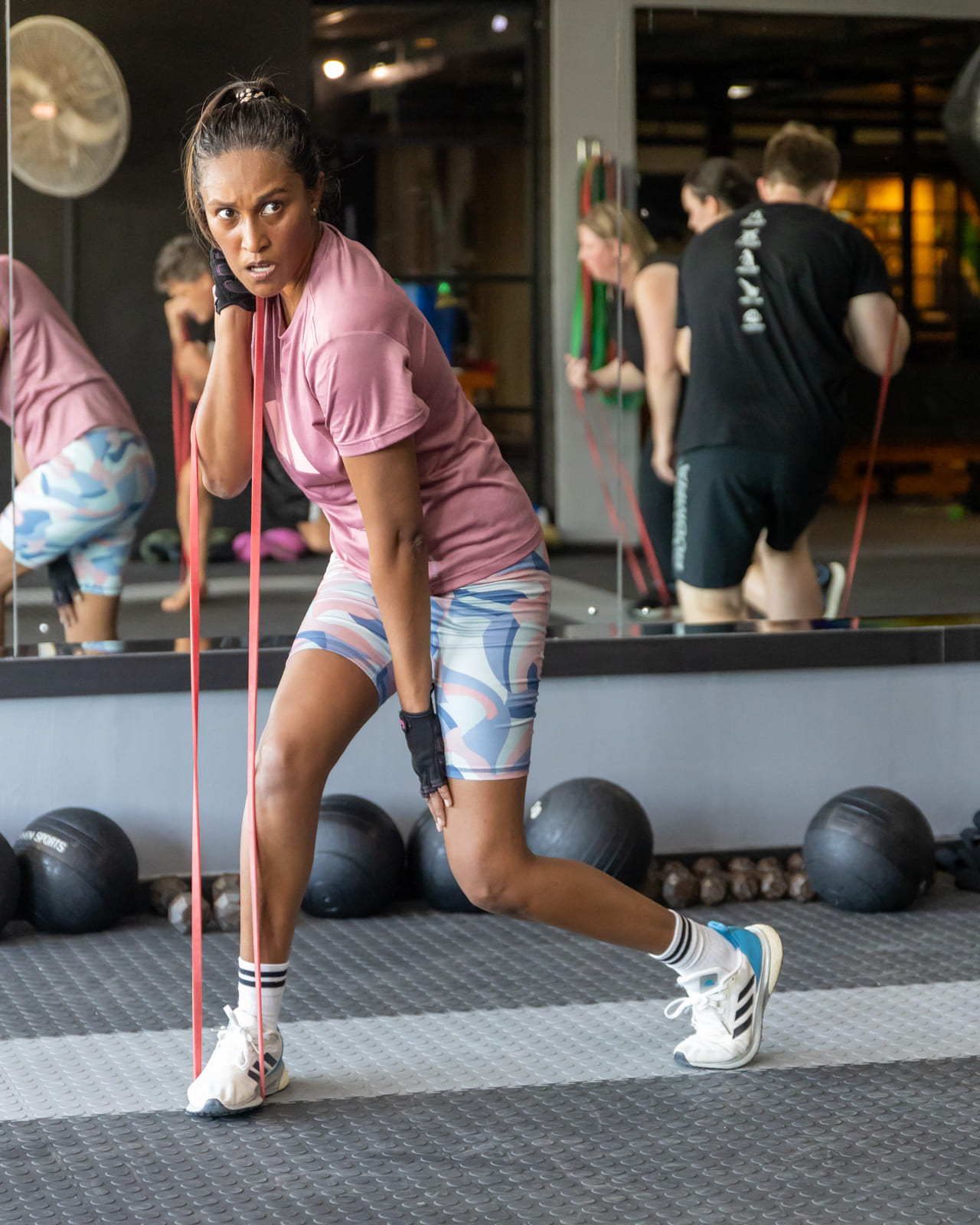 Adult student performing resistance training during a supervised fitness class focused on strength, control, and conditioning.